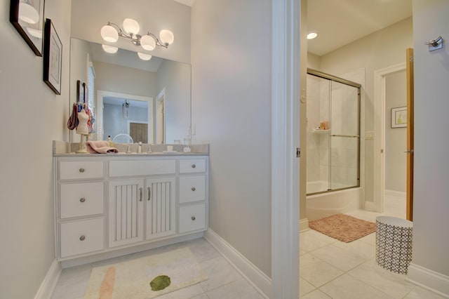 bathroom with bath / shower combo with glass door, tile patterned floors, and vanity