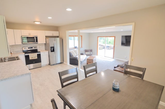 dining space featuring sink and light hardwood / wood-style flooring