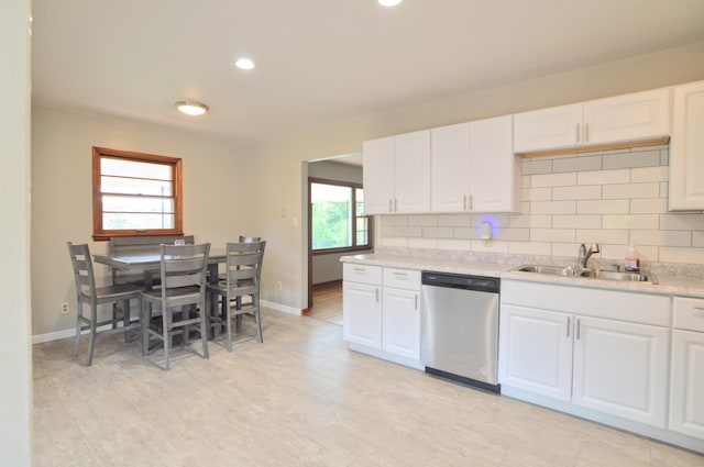 kitchen with stainless steel dishwasher, white cabinets, and plenty of natural light