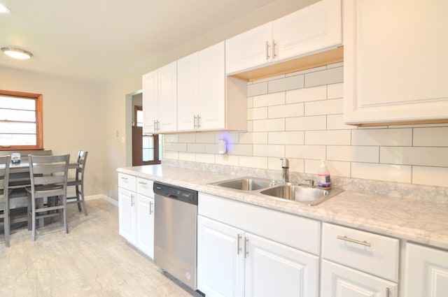 kitchen featuring white cabinets, sink, tasteful backsplash, and stainless steel dishwasher