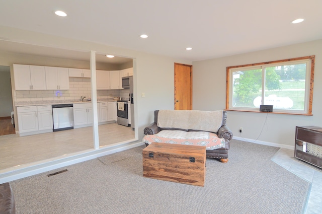 living room featuring sink and light tile patterned floors