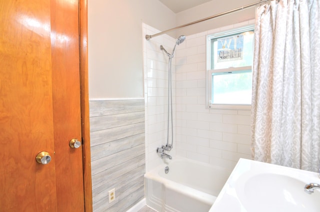 bathroom with tile walls, shower / tub combo, and sink