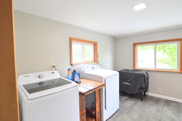 washroom with light tile patterned floors, plenty of natural light, and independent washer and dryer