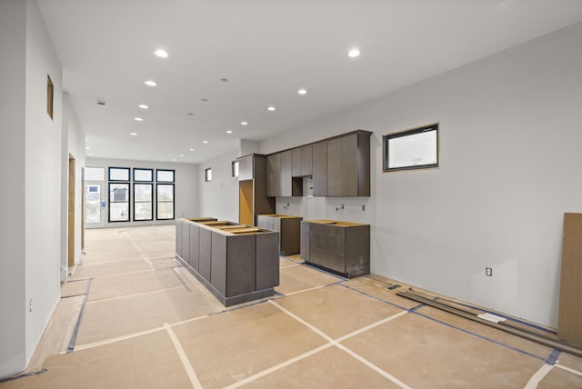 kitchen featuring dark brown cabinets, a kitchen island, and light tile patterned floors