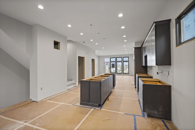 kitchen with decorative backsplash, a kitchen island, and light tile patterned flooring