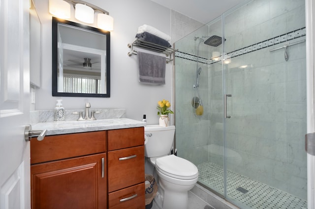 bathroom with a shower with door, vanity, and toilet