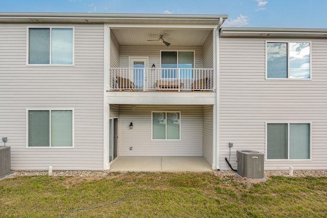 rear view of house with a lawn, cooling unit, and a balcony