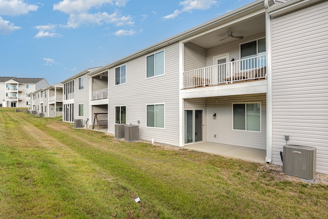 exterior space featuring a lawn, cooling unit, and a patio area