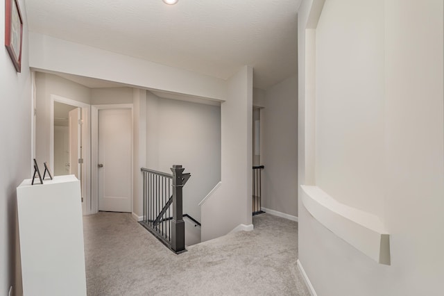 corridor featuring light colored carpet