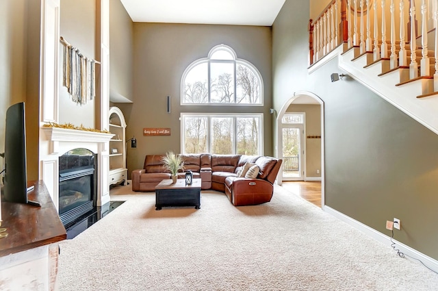 carpeted living room featuring a high ceiling