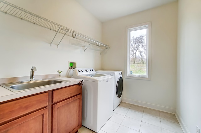 clothes washing area featuring light tile patterned flooring, cabinets, sink, and washing machine and dryer