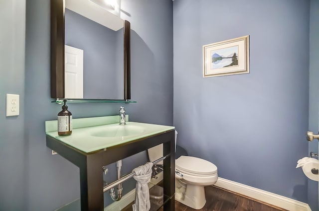 bathroom featuring toilet, vanity, and hardwood / wood-style flooring