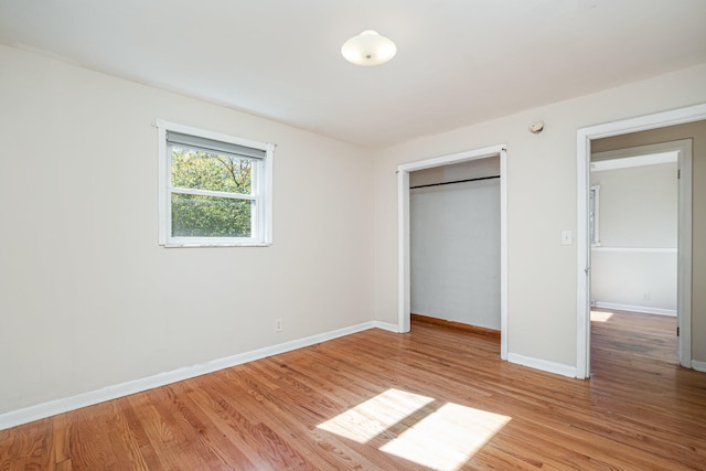 unfurnished bedroom featuring light wood-type flooring and a closet