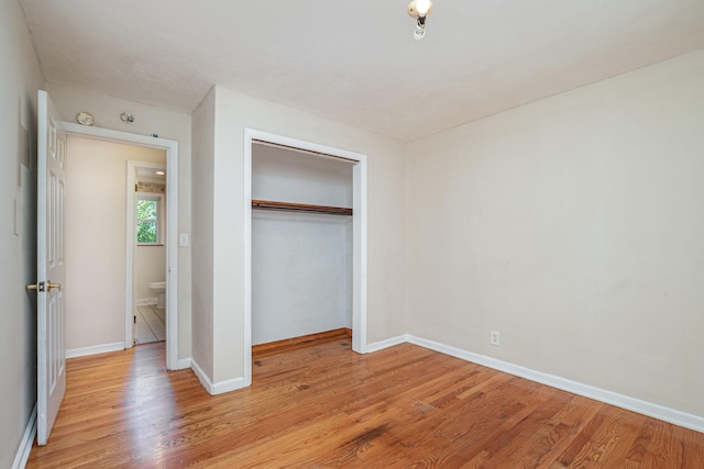 unfurnished bedroom featuring light hardwood / wood-style flooring and a closet