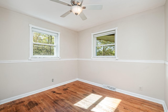 unfurnished room featuring hardwood / wood-style flooring, ceiling fan, and a wealth of natural light