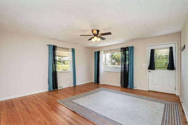 foyer entrance with wood-type flooring, ceiling fan, and plenty of natural light