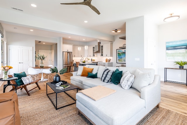 living room featuring light wood-type flooring and ceiling fan