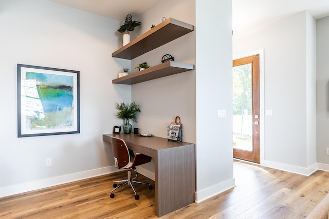 home office with light hardwood / wood-style floors