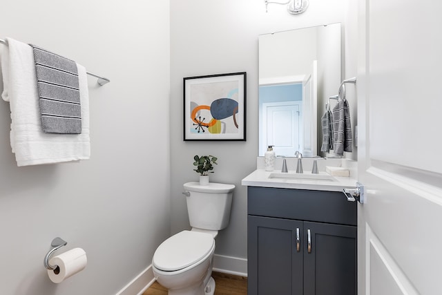 bathroom with hardwood / wood-style floors, vanity, and toilet