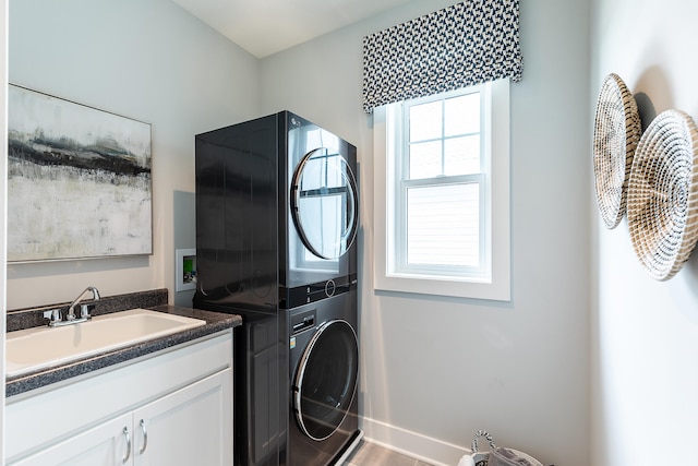 laundry room with cabinets, sink, stacked washer / drying machine, and hardwood / wood-style flooring