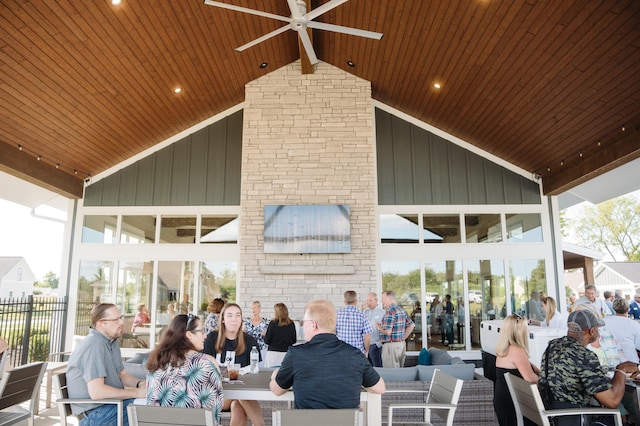 exterior space featuring wood ceiling, vaulted ceiling, ceiling fan, and plenty of natural light