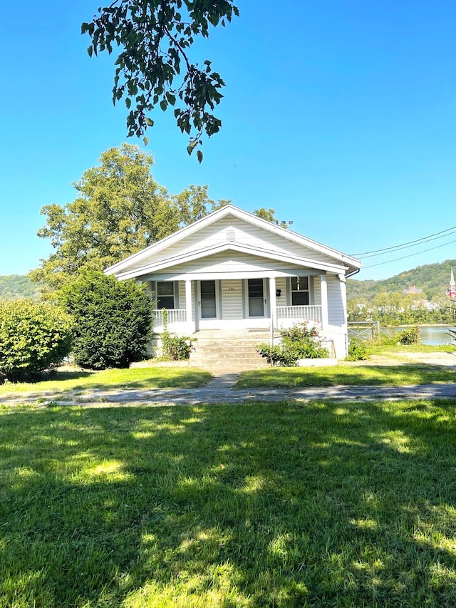 view of front of home with a front yard and covered porch