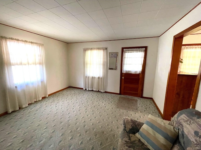 carpeted entrance foyer featuring crown molding