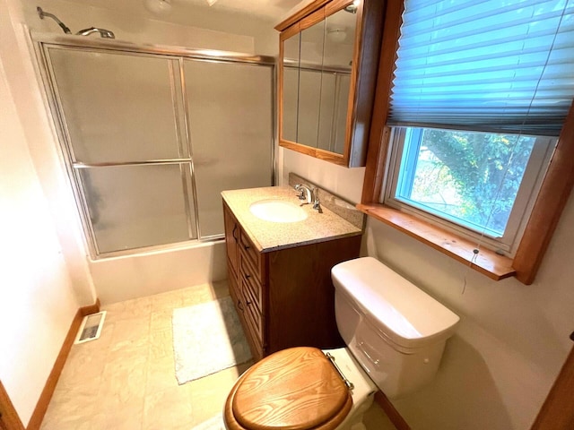 full bathroom with bath / shower combo with glass door, vanity, and toilet