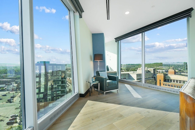 interior space with a wall of windows and hardwood / wood-style flooring