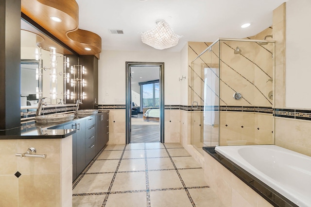 bathroom with vanity, a chandelier, plus walk in shower, and tile walls