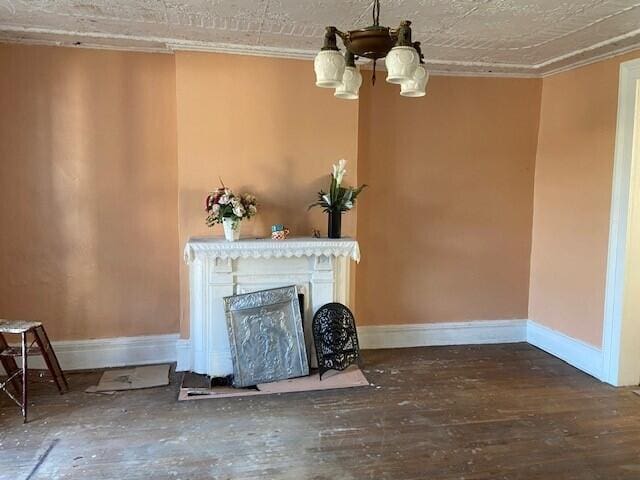 unfurnished living room featuring a textured ceiling, crown molding, dark hardwood / wood-style floors, and a chandelier