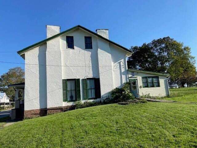 view of property exterior with a lawn