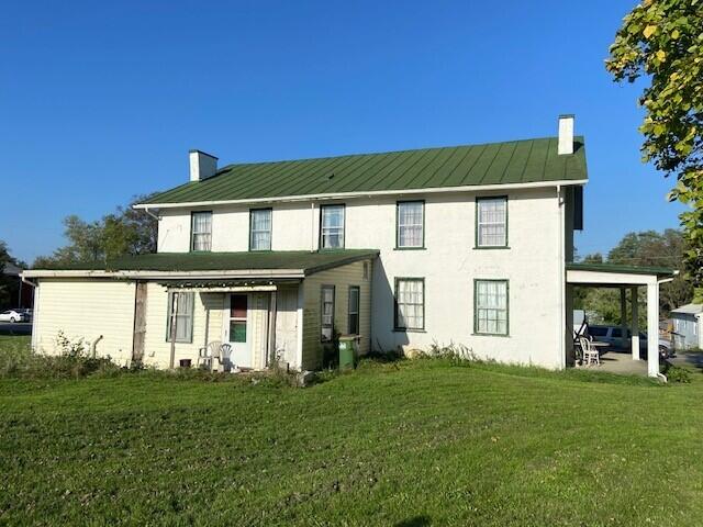 back of property featuring a lawn and a patio area