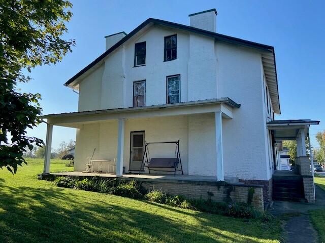 back of house with a lawn and a porch