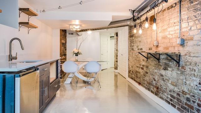 interior space featuring visible vents, brick wall, refrigerator, and a sink
