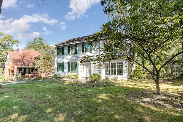 colonial-style house featuring a front lawn