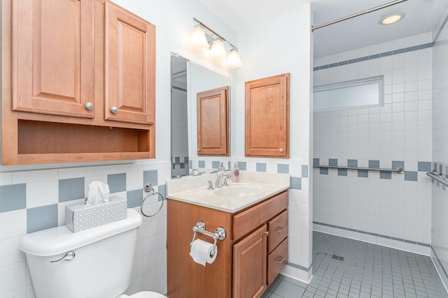 full bath featuring tile walls, toilet, decorative backsplash, vanity, and tiled shower