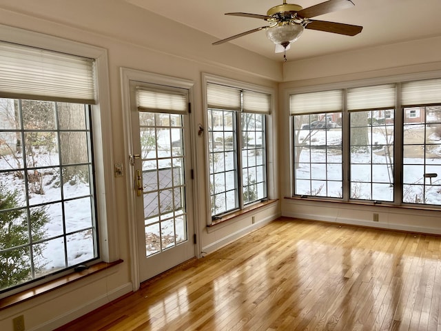 unfurnished sunroom featuring ceiling fan