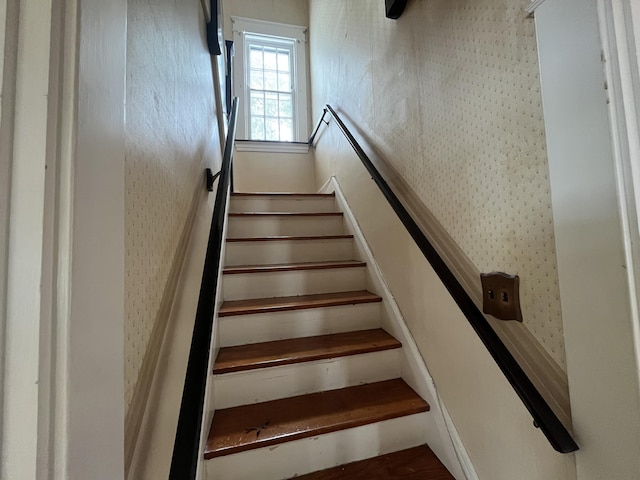 staircase with wallpapered walls