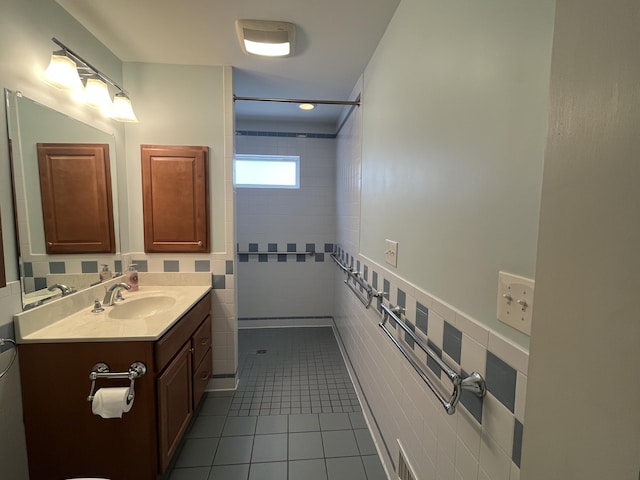 full bath featuring a shower, tile walls, visible vents, vanity, and tile patterned flooring