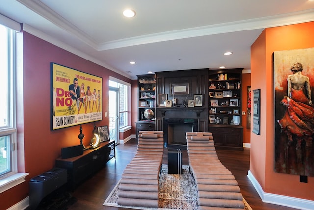 living room featuring a fireplace, crown molding, dark hardwood / wood-style floors, and a wealth of natural light