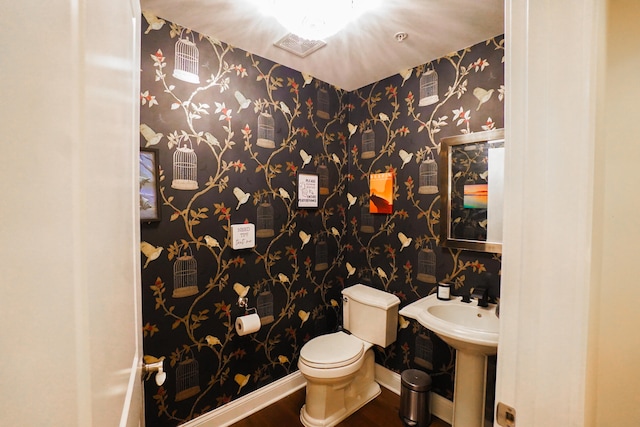 bathroom with hardwood / wood-style flooring, sink, and toilet