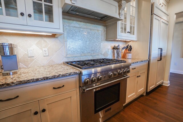 kitchen featuring wall chimney exhaust hood, light stone countertops, dark hardwood / wood-style floors, and stainless steel stove