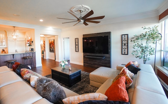 living room featuring ornamental molding, ceiling fan, and dark wood-type flooring