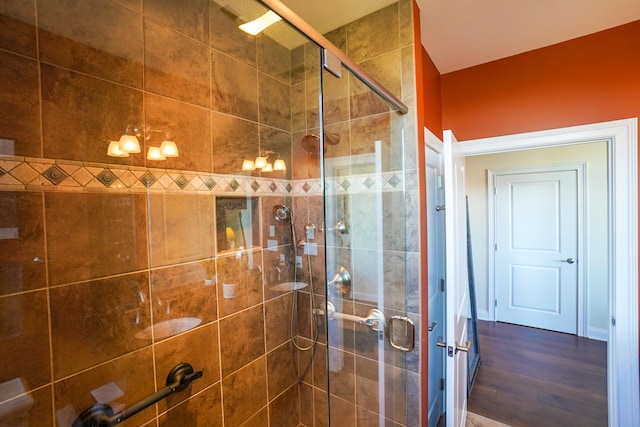 bathroom featuring wood-type flooring and a shower with door