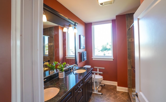 bathroom featuring tile patterned flooring, vanity, a shower with door, and toilet