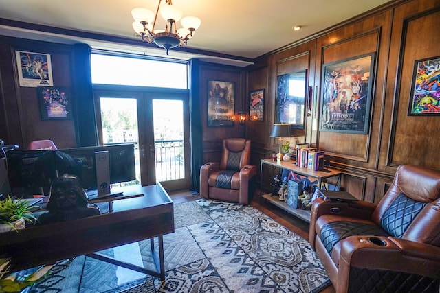 home office featuring french doors, an inviting chandelier, wooden walls, and hardwood / wood-style flooring