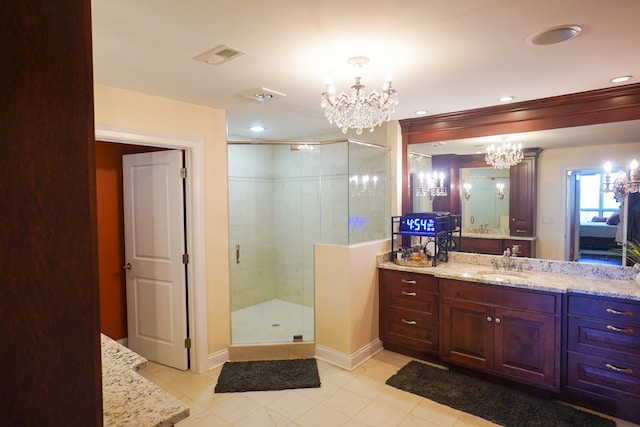 bathroom with tile patterned flooring, a shower with door, vanity, and an inviting chandelier