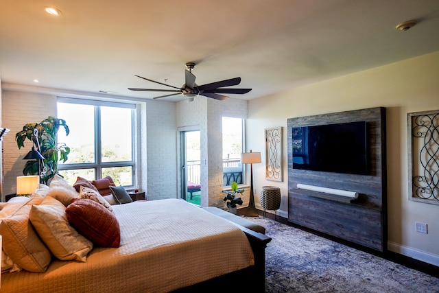 bedroom with ceiling fan, brick wall, and wood-type flooring