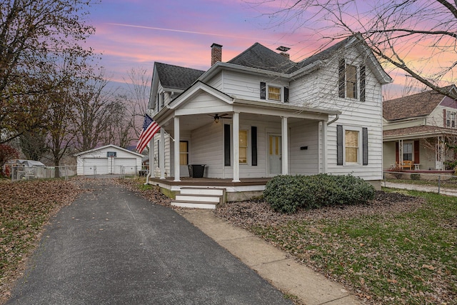 view of front of property with an outdoor structure, a porch, and a garage